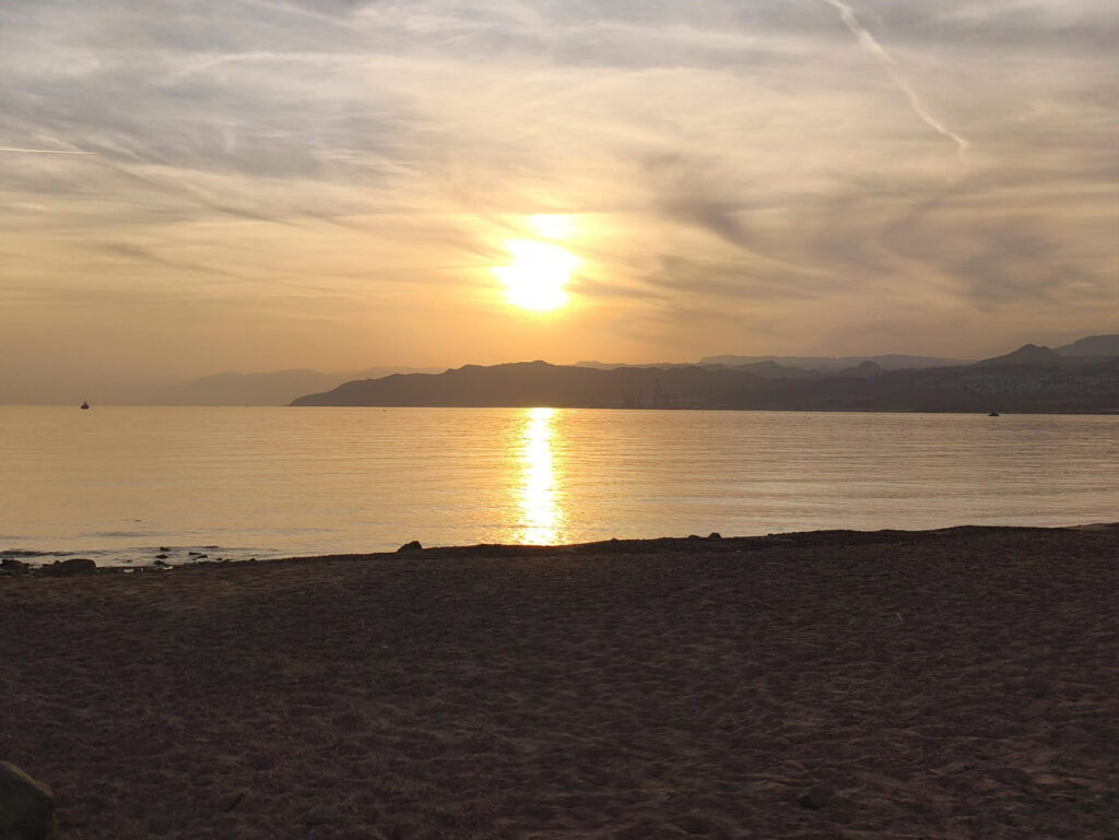 קצה חוף מפרץ השמש בשקיעה, ליד הגבול המזרחי של אילת